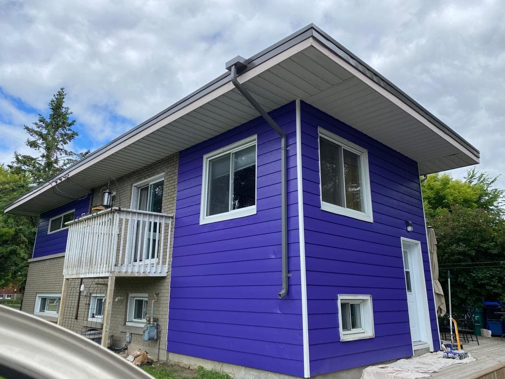 Two-storey home with newly painted deep purple siding and crisp white trim